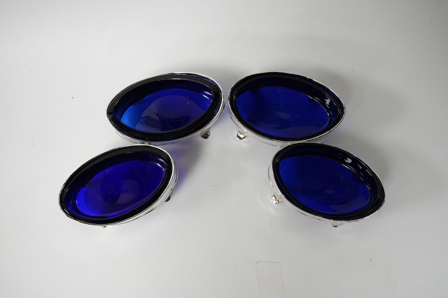 A set of four George III silver oval salts (a.f.) with blue glass liners, London, 1800, 83mm. Condition - poor